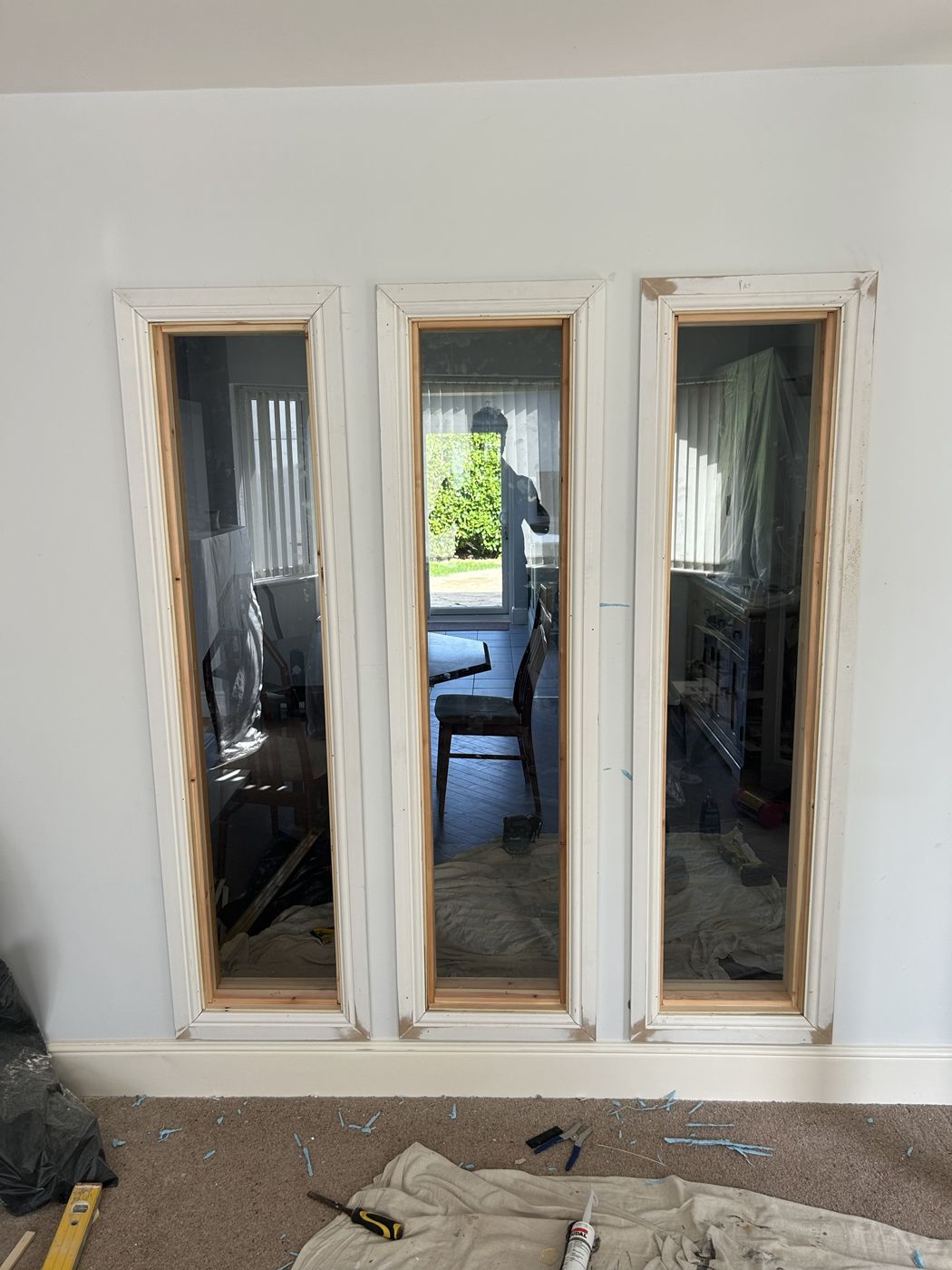 Three tall glazed panels framed into an internal wall