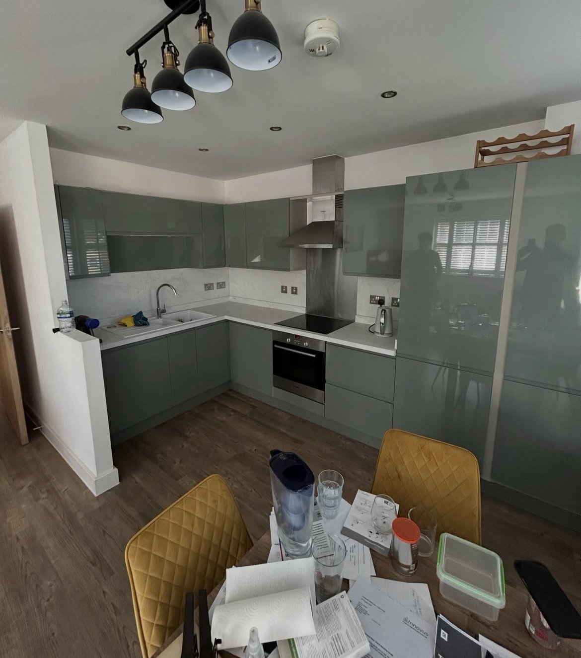 Fitted kitchen with sage-green handleless units and white worktops