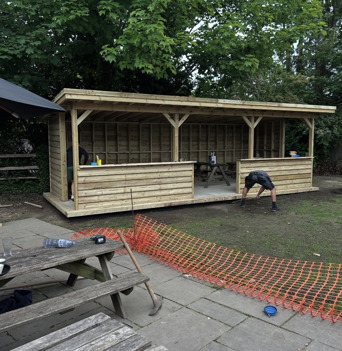 Large timber outdoor seating shelter in a pub garden